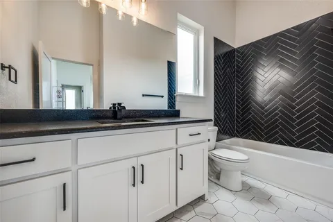 a bathroom with a granite countertop sink a mirror and a shower
