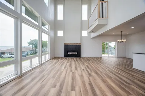 a view of empty room with wooden floor and fireplace