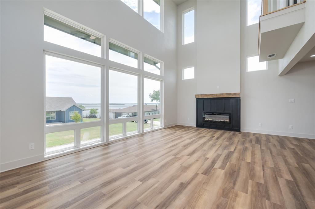 614 Twin Hills Road Lake Bridgeport, TX 76426 - Photo 7 of 25 a view of empty room with wooden floor and fireplace