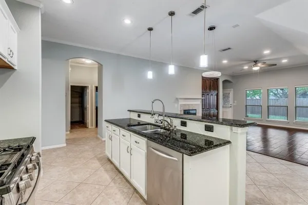 a kitchen with stainless steel appliances granite countertop a sink and a stove