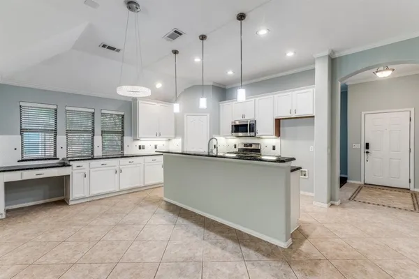 a large kitchen with cabinets and stainless steel appliances