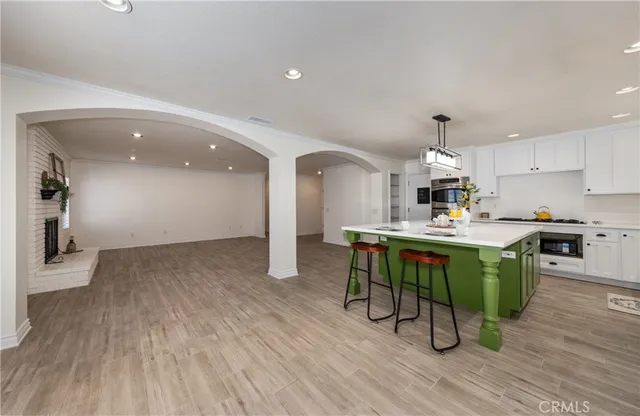 a view of a livingroom with a window a ceiling fan and wooden floor