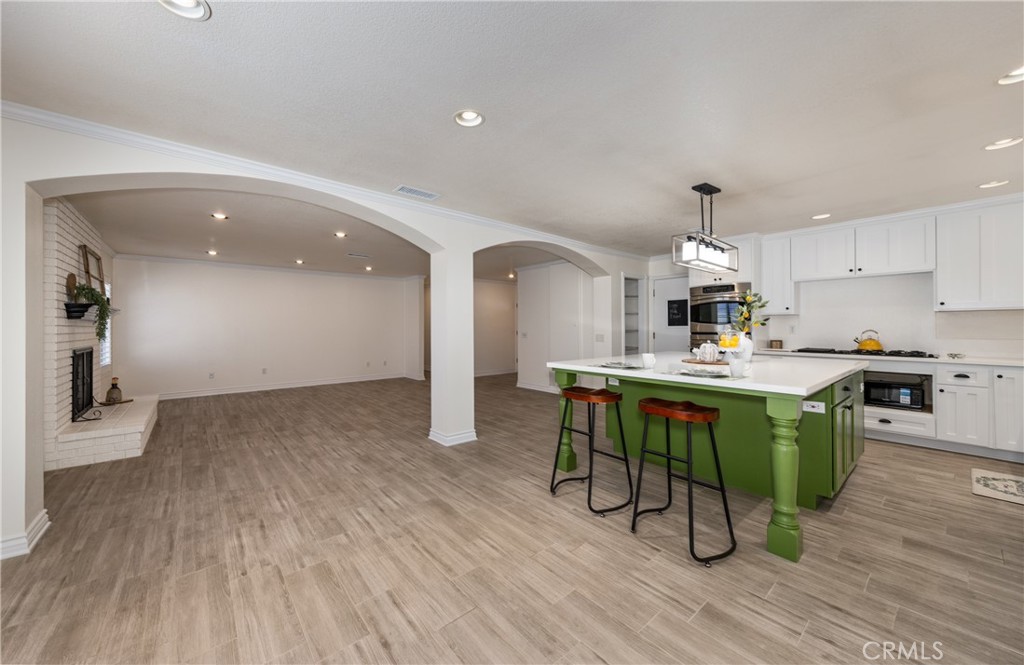 12780 Blossom Avenue Yucaipa, CA 92399 - Photo 12 of 31 a kitchen with stainless steel appliances granite countertop a refrigerator a stove top oven a sink dishwasher and white cabinets with wooden floor