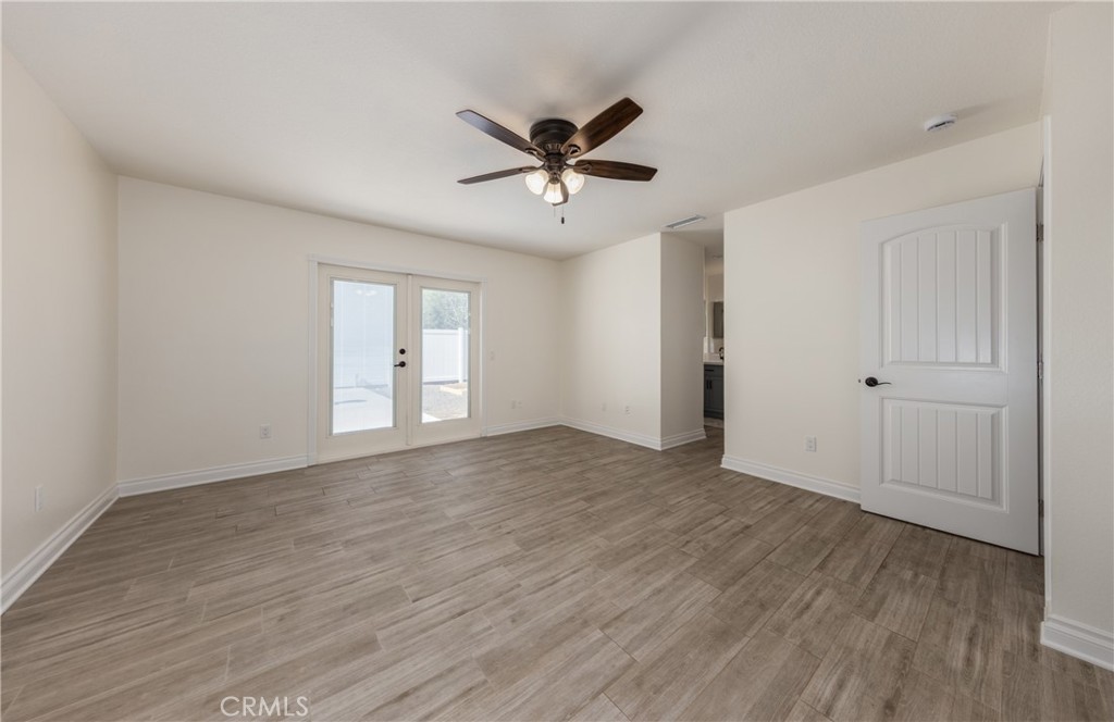 12780 Blossom Avenue Yucaipa, CA 92399 - Photo 13 of 31 a view of a livingroom with a window a ceiling fan and wooden floor