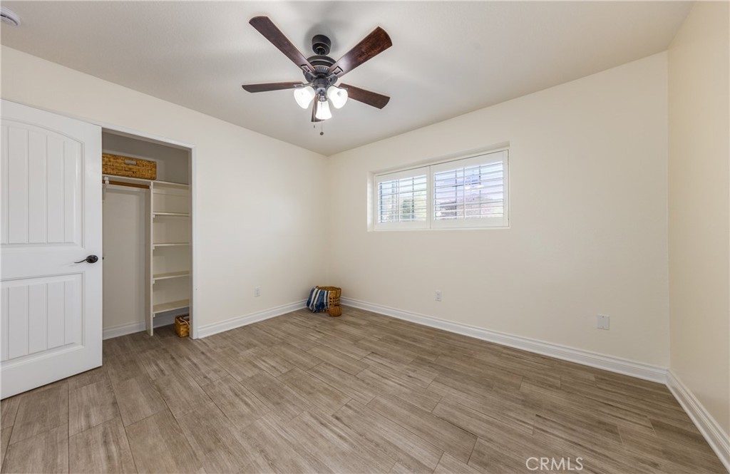 12780 Blossom Avenue Yucaipa, CA 92399 - Photo 17 of 31 an empty room with wooden floor and windows