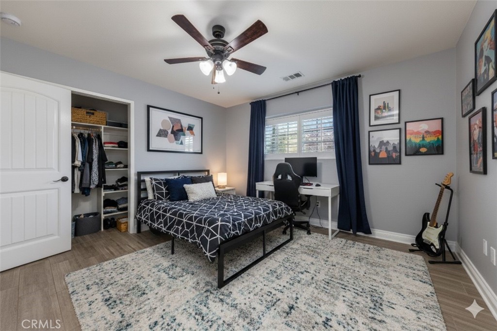 12780 Blossom Avenue Yucaipa, CA 92399 - Photo 18 of 31 a bedroom with a bed painting on wall and a large window