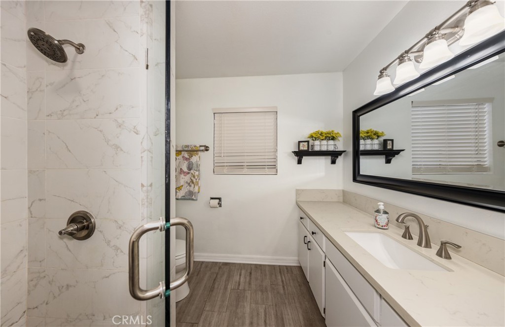 12780 Blossom Avenue Yucaipa, CA 92399 - Photo 19 of 31 a bathroom with a granite countertop sink a mirror and shower