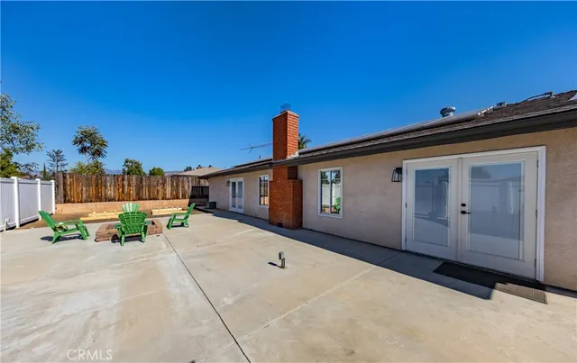 a view of a patio with table and chairs with wooden fence and plants