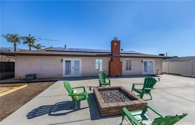 a patio with table and chairs and potted plants