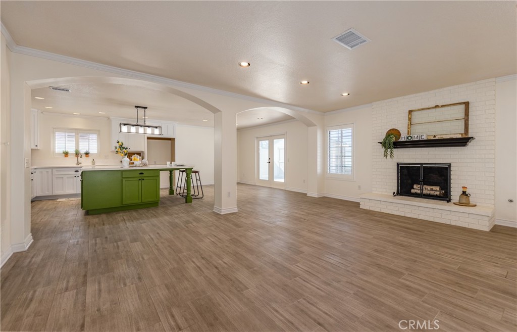 12780 Blossom Avenue Yucaipa, CA 92399 - Photo 5 of 31 a room with a fireplace and a kitchen view