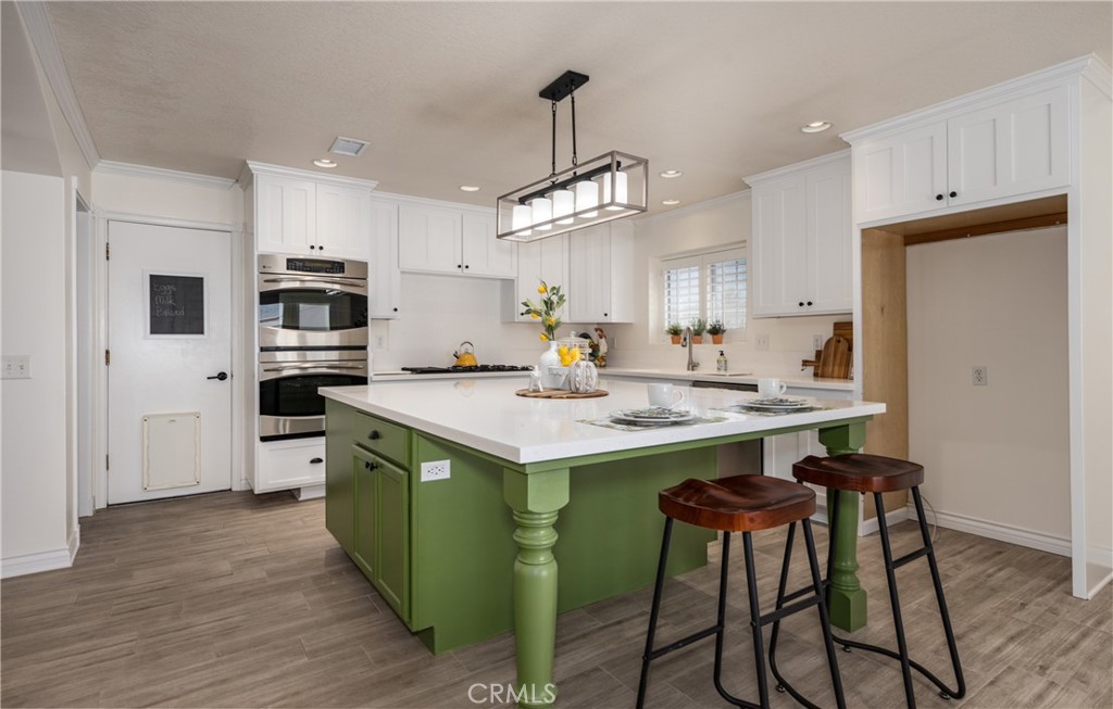 12780 Blossom Avenue Yucaipa, CA 92399 - Photo 9 of 31 a kitchen with wooden cabinets and white appliances