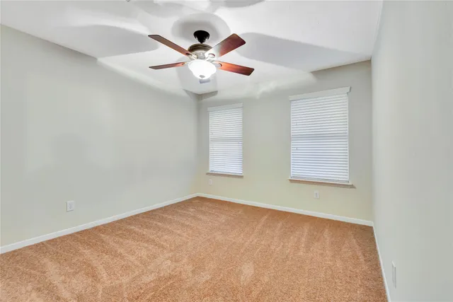 an empty room with closet and fan