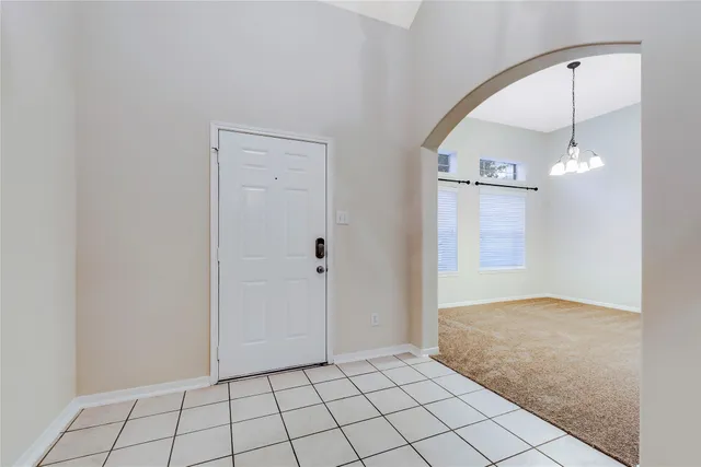 an empty room with fan and entryway