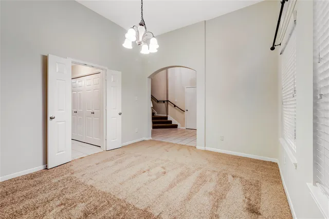 a view of a room with a chandelier and wooden floor