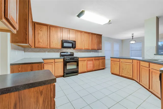 a kitchen with granite countertop cabinets and black stainless steel appliances