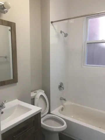 a bathroom with a sink mirror toilet and bathtub