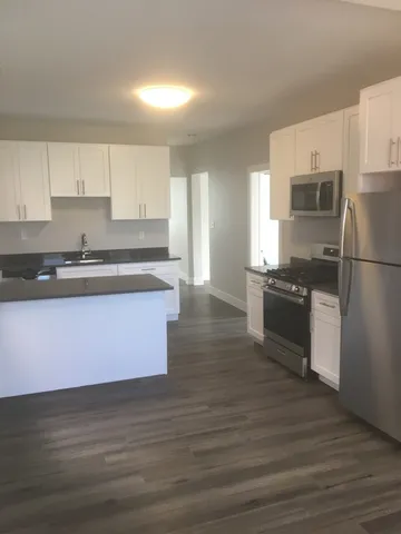 a kitchen with granite countertop a sink cabinets and stainless steel appliances