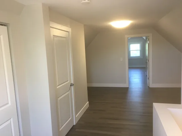 a view of a hallway with wooden floor