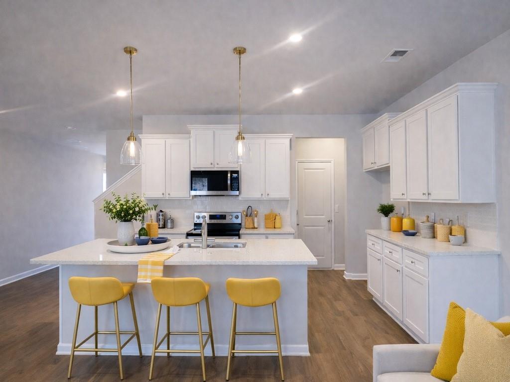 6359 Towhee Way Morrow, GA 30260 - Photo 4 of 36 a kitchen with stainless steel appliances kitchen island granite countertop a dining table chairs sink and cabinets