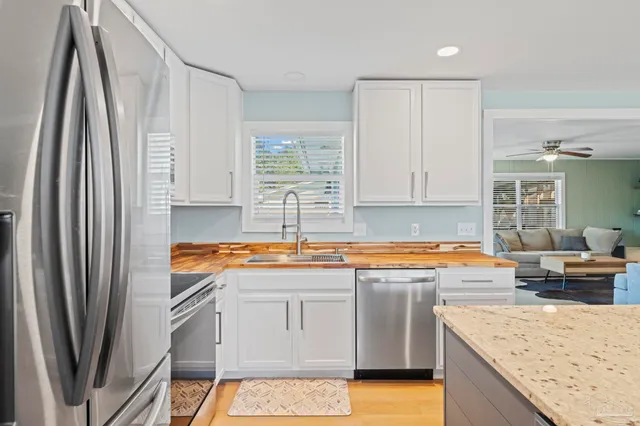 a kitchen with granite countertop a stove sink and refrigerator