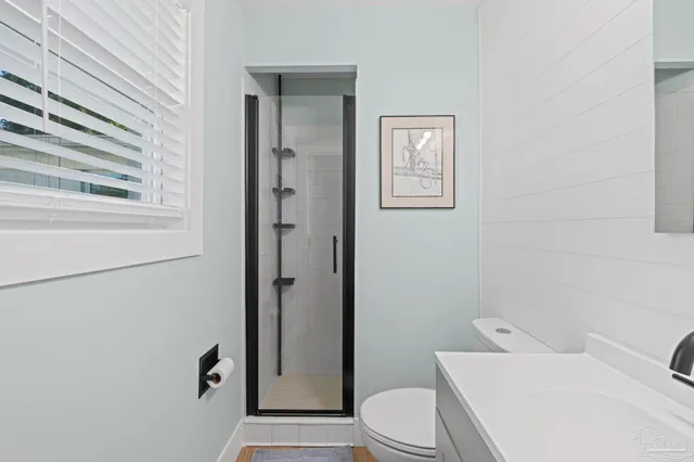 a bathroom with a toilet sink vanity and mirror
