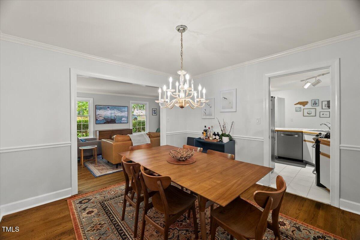 6117 Dodsworth Drive Raleigh, NC 27612 - Photo 11 of 54 a view of a dining room with furniture a chandelier and wooden floor
