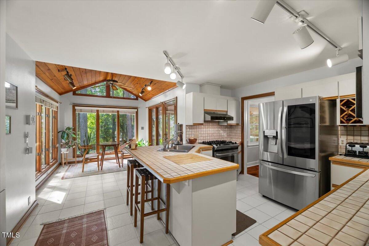 6117 Dodsworth Drive Raleigh, NC 27612 - Photo 12 of 54 a kitchen that has a lot of cabinets a sink and appliances in it