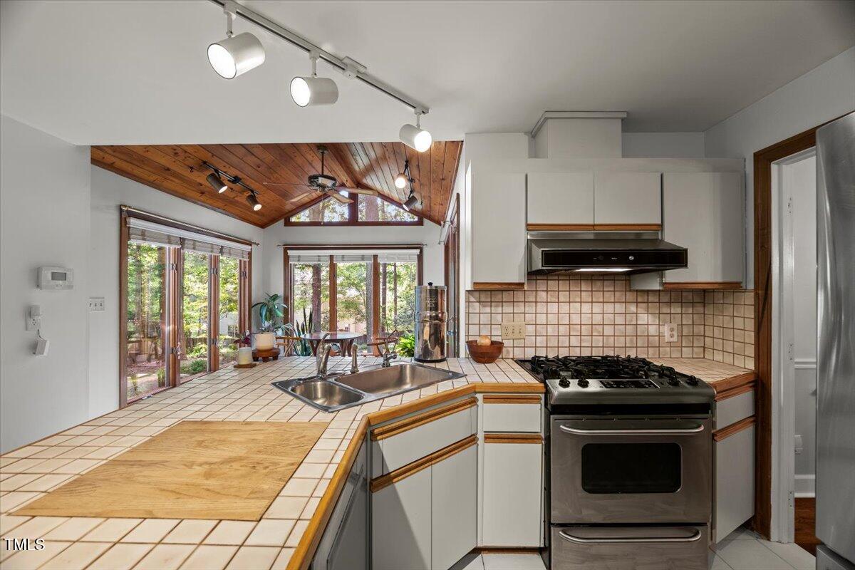 6117 Dodsworth Drive Raleigh, NC 27612 - Photo 16 of 54 a kitchen with stainless steel appliances a stove a sink and a microwave
