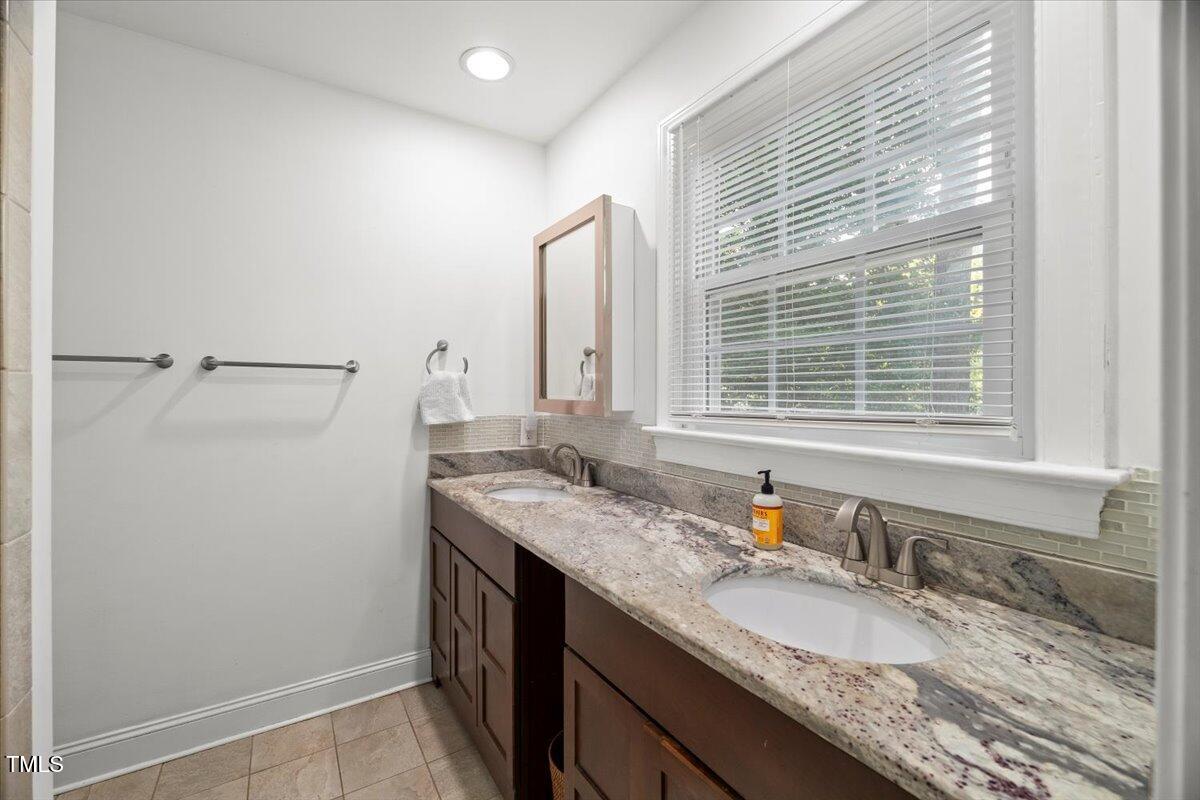 6117 Dodsworth Drive Raleigh, NC 27612 - Photo 23 of 54 a bathroom with a granite countertop sink and a mirror