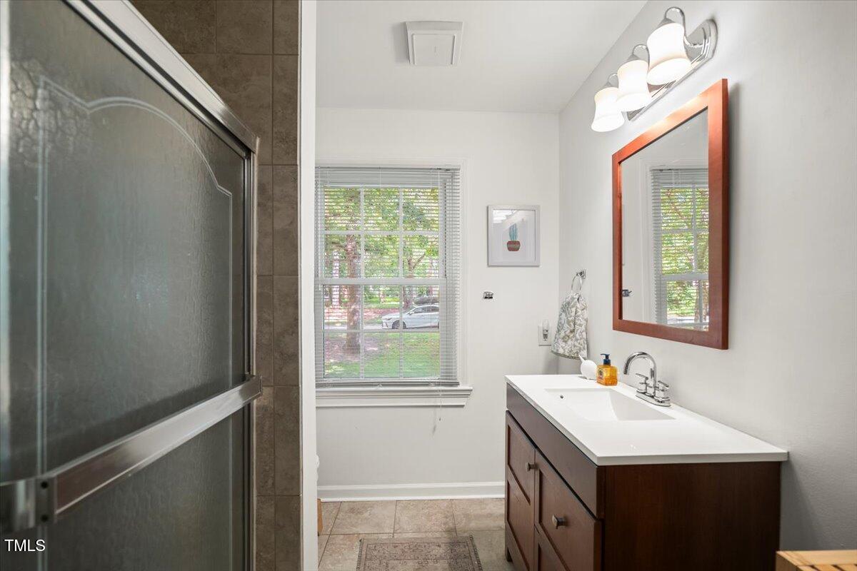 6117 Dodsworth Drive Raleigh, NC 27612 - Photo 27 of 54 a bathroom with a sink a vanity and a mirror