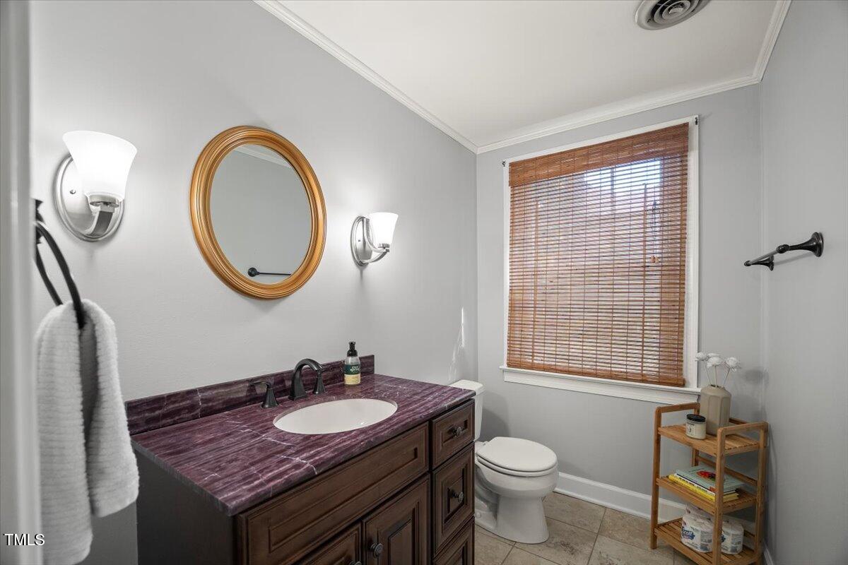 6117 Dodsworth Drive Raleigh, NC 27612 - Photo 34 of 54 a bathroom with a granite countertop toilet a sink and a mirror