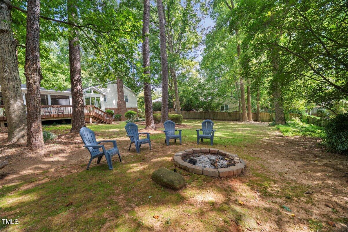 6117 Dodsworth Drive Raleigh, NC 27612 - Photo 45 of 54 a view of a backyard with table and chairs under an umbrella