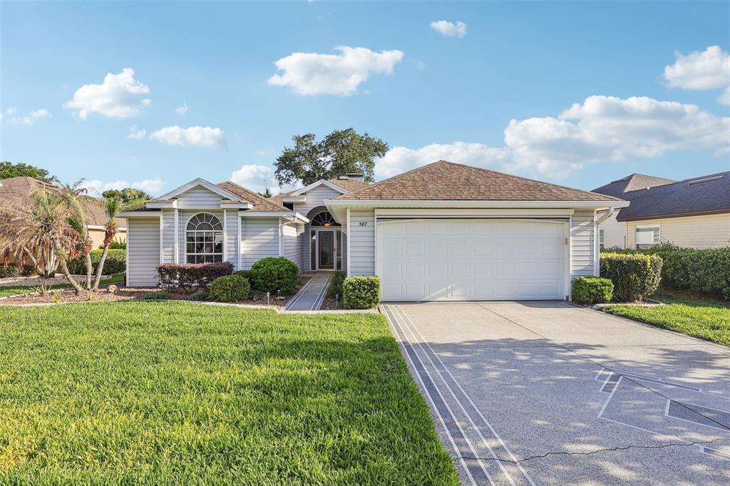 a front view of a house with a yard and garage