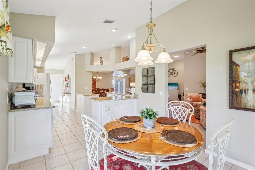 587 Juniper Way Tavares, FL 32778 - Photo 18 of 56 a dining room filled a chandelier and kitchen view