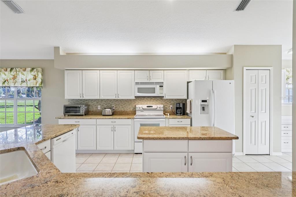 587 Juniper Way Tavares, FL 32778 - Photo 20 of 56 a kitchen with stainless steel appliances granite countertop a stove a sink and a refrigerator