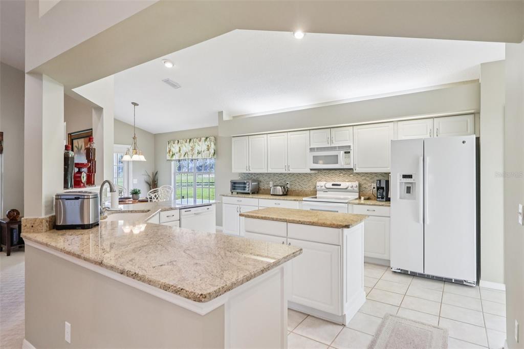 587 Juniper Way Tavares, FL 32778 - Photo 21 of 56 a kitchen with stainless steel appliances granite countertop a sink and cabinets