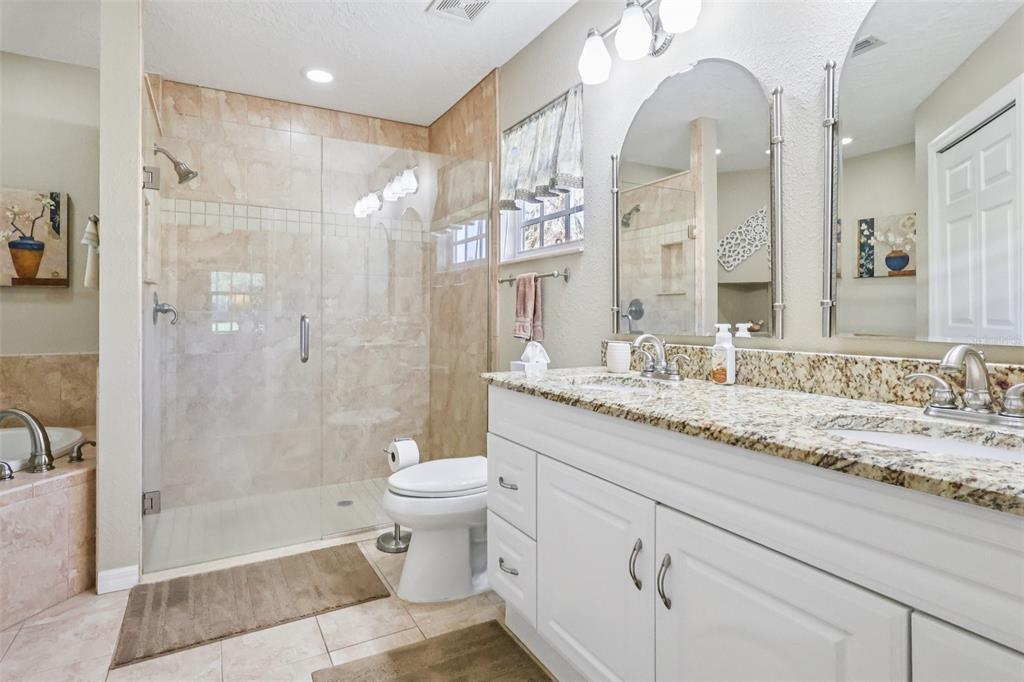 587 Juniper Way Tavares, FL 32778 - Photo 27 of 56 a bathroom with a granite countertop sink a toilet and shower