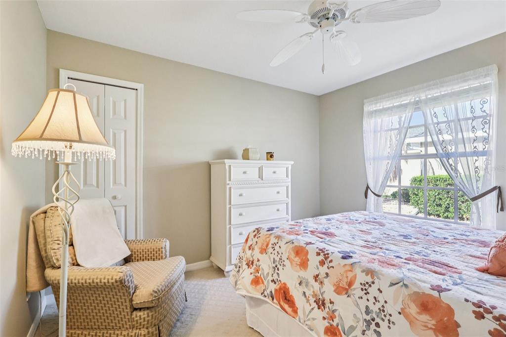 587 Juniper Way Tavares, FL 32778 - Photo 30 of 56 a bedroom with a bed and a chandelier