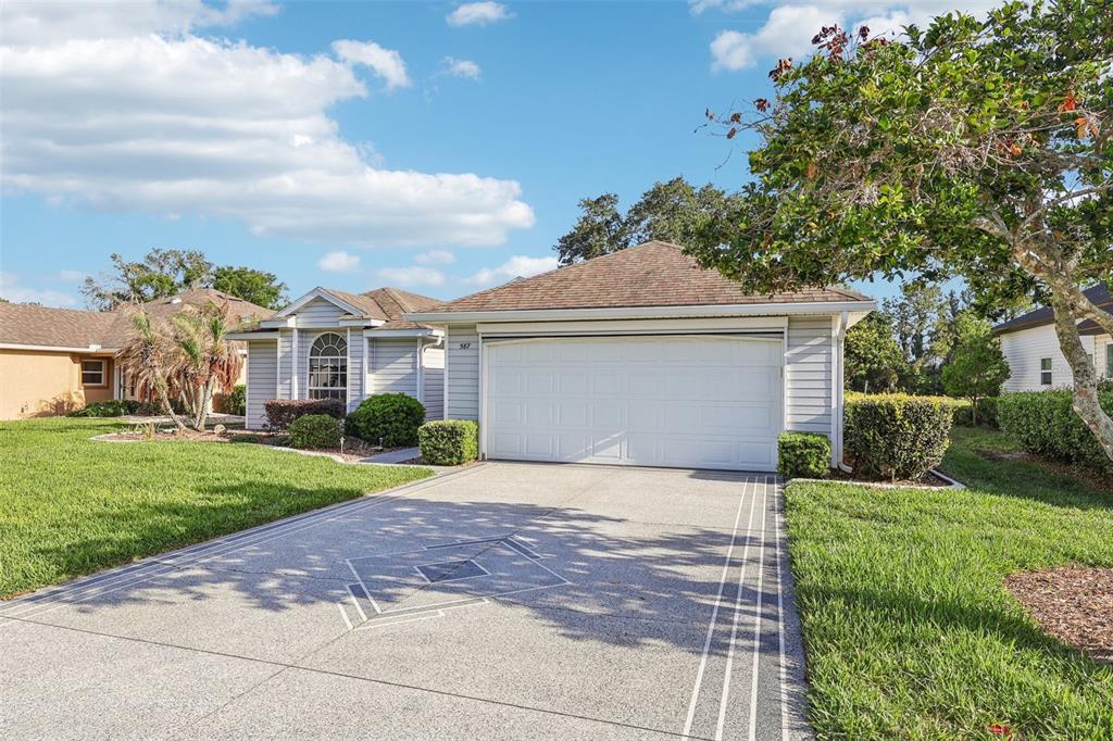 587 Juniper Way Tavares, FL 32778 - Photo 3 of 56 a front view of a house with a yard and garage