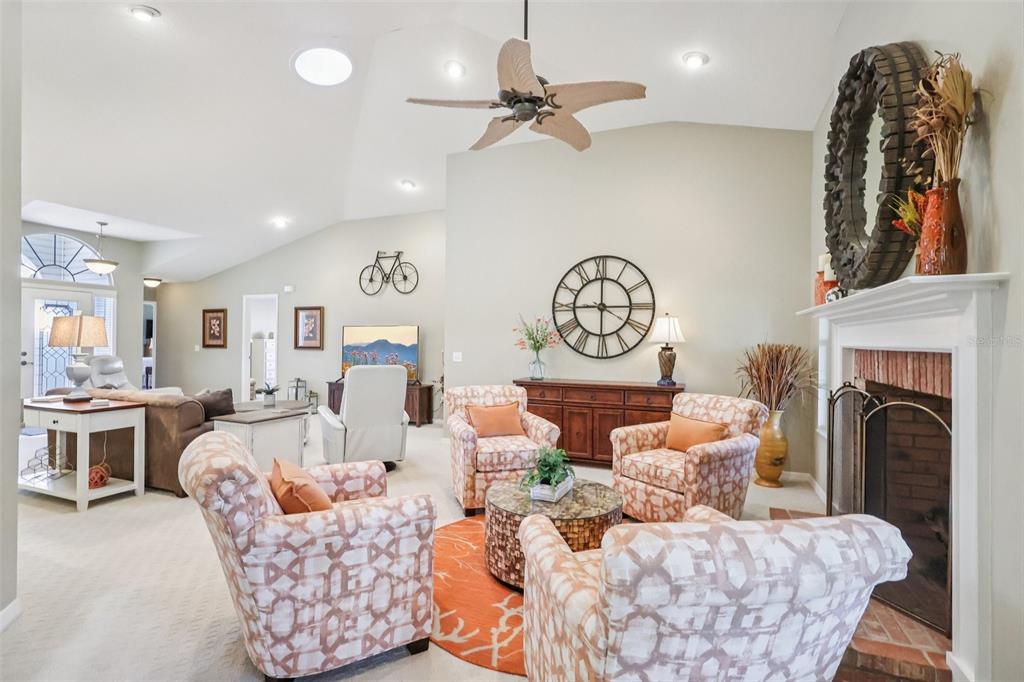 587 Juniper Way Tavares, FL 32778 - Photo 7 of 56 a living room with furniture a fireplace and a chandelier