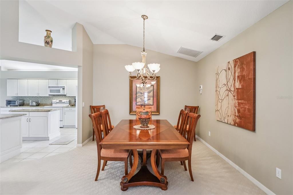 587 Juniper Way Tavares, FL 32778 - Photo 10 of 56 a dining room with furniture a chandelier and window