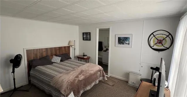 a bedroom with a bed a mirror and dresser