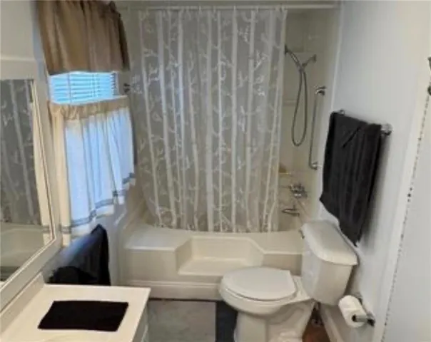 a bathroom with a toilet and a shower curtain