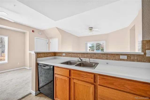 an empty room with a kitchen space and windows
