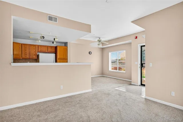 a view of an empty room with a ceiling fan