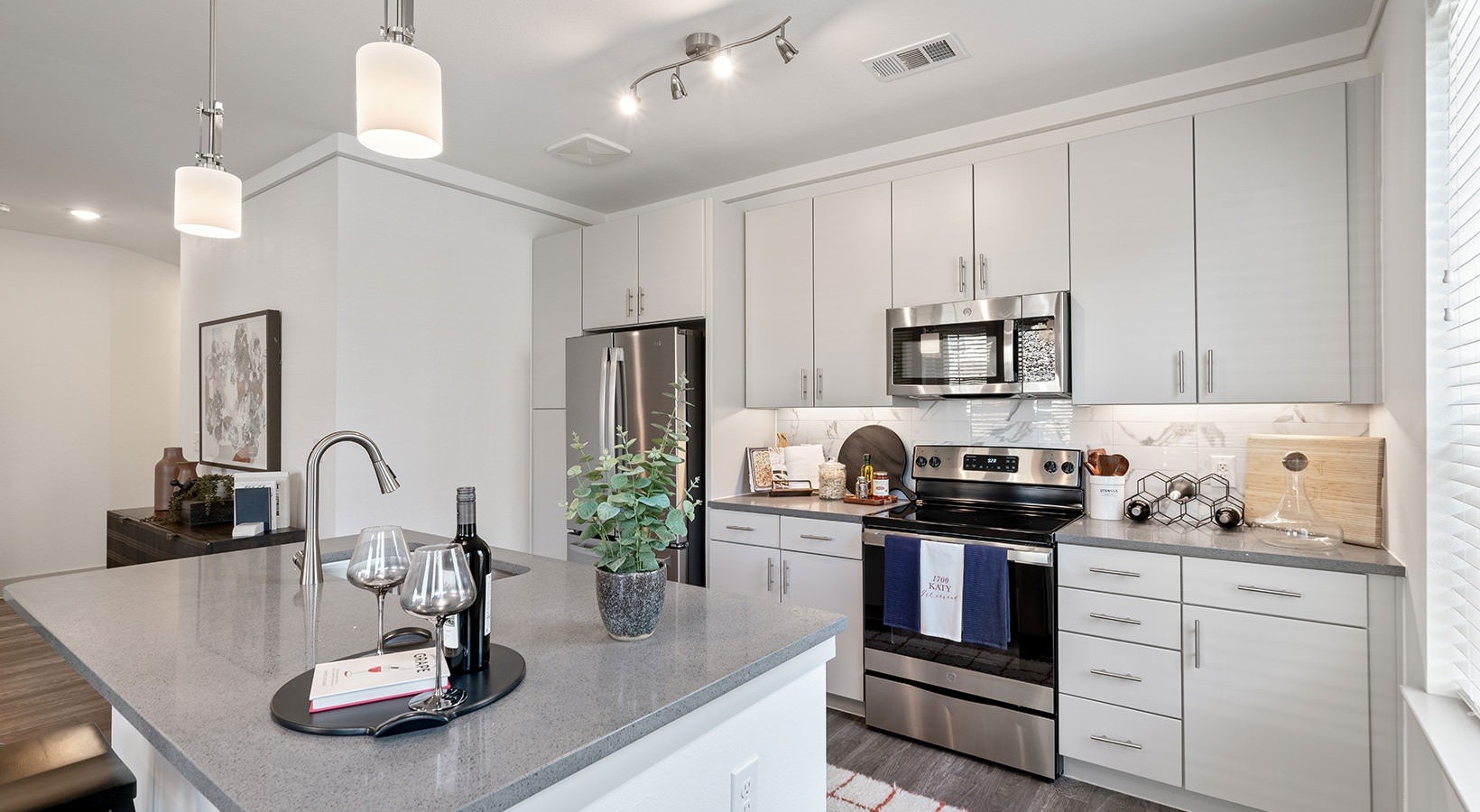 1700 Katy Fort Bend Road, Unit 2107 Katy, TX 77493 - Photo 7 of 30 a kitchen with a sink dishwasher a stove and white cabinets with wooden floor
