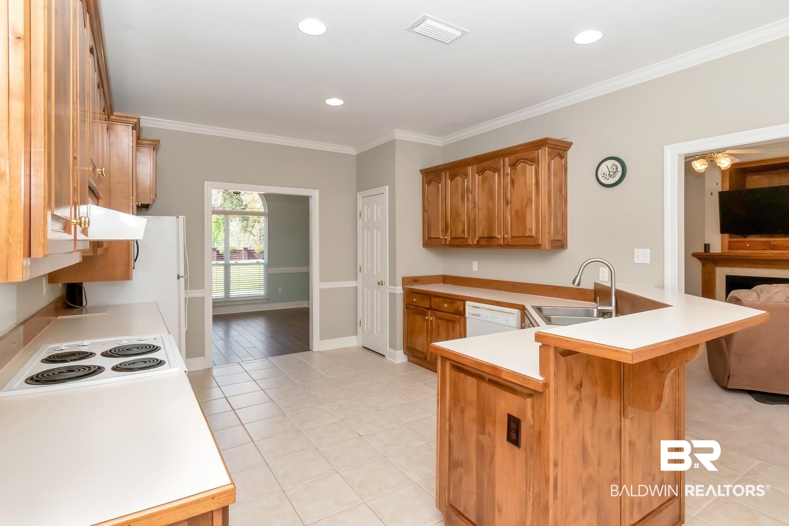 6090 Celeste Road Saraland, AL 36571 - Photo 10 of 38 Kitchen featuring visible vents, crown molding, light countertops, and a peninsula