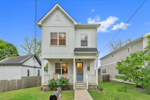 a view of a house with a yard and potted plants