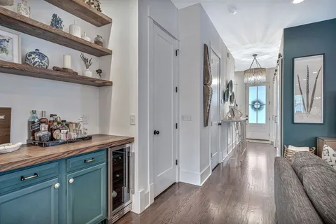 a view of a hallway with wooden floor and cabinets