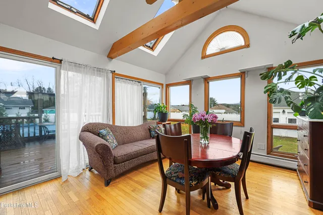 a view of a hallway with wooden floor and a bathroom